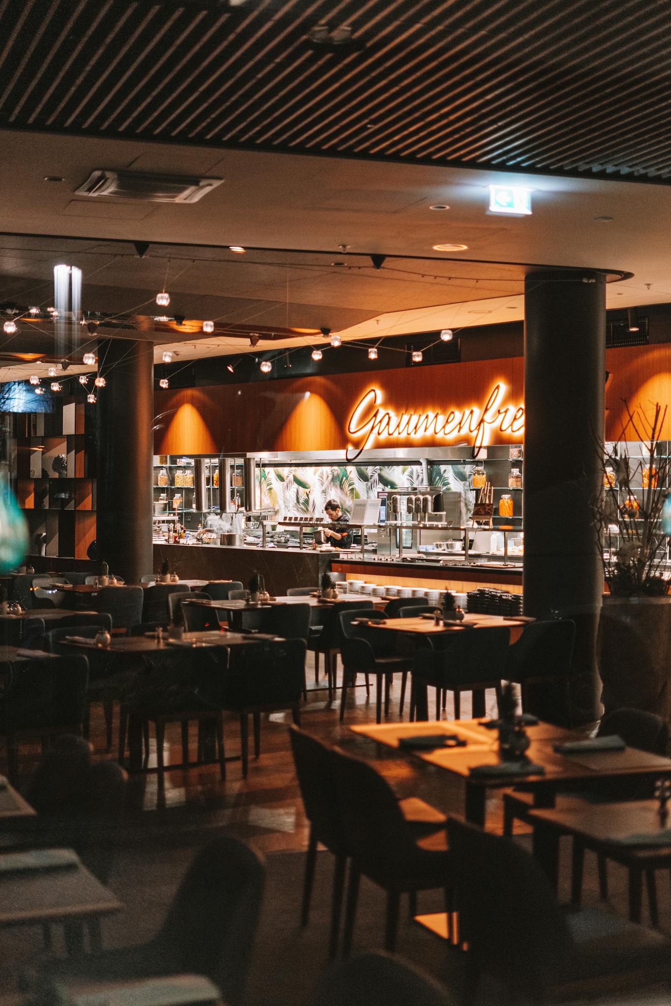 Warm and inviting interior of a stylish restaurant with empty tables and modern decor.